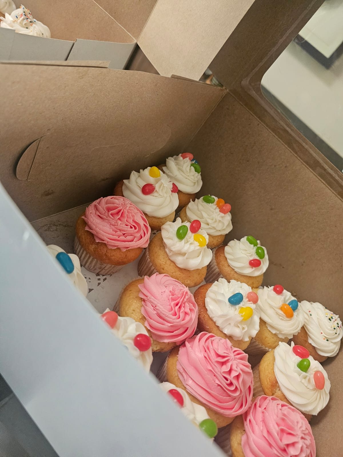 Vanilla cupcakes decorated with pink and white buttercream and colourful jelly beans