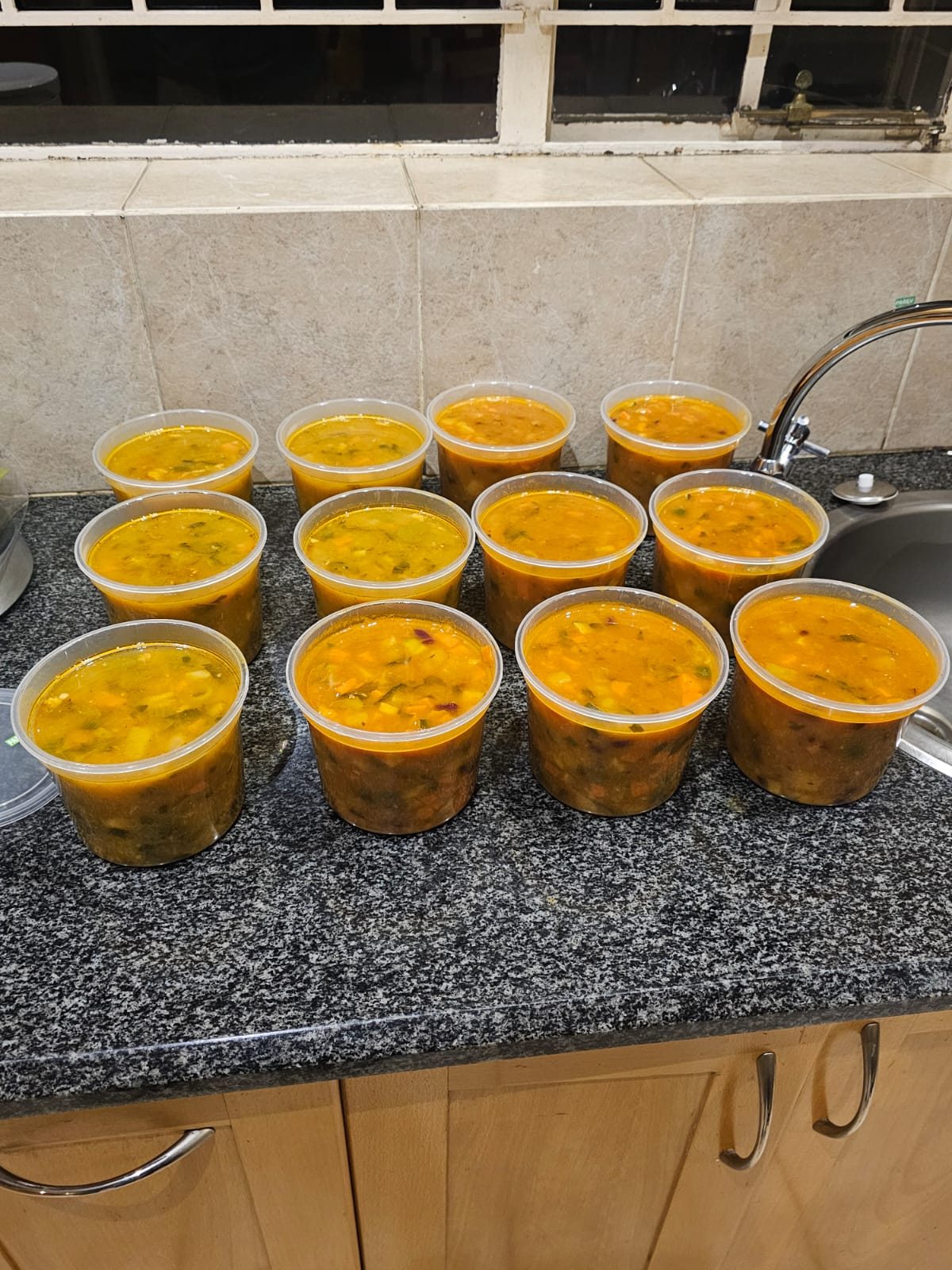 A fresh batch of hearty soup portioned into family-size containers
